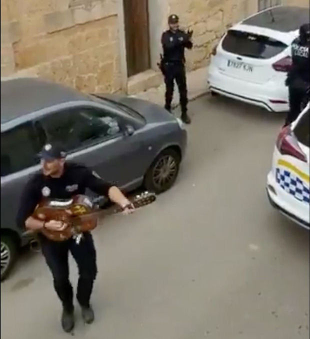 Khoảnh khắc hạnh phúc giữa lúc buồn chán: Anh cảnh sát chơi guitar hát cho cả phố nghe, xua đi bầu không khí u ám vì Covid-19 - Ảnh 1.