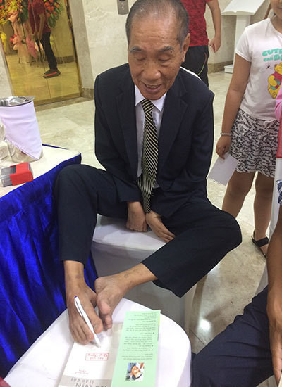 Thầy giáo Nguyễn Ngọc Ký ký tặng sách bạn đọc tại sự kiện ra mắt cuốn Tâm huyết trao đời năm 2017. Ảnh: Thoại Hà